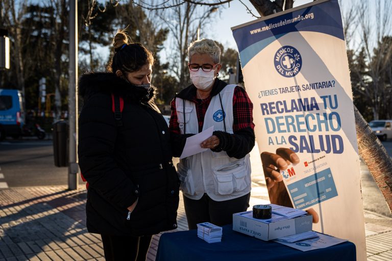 Voluntaria de Médicos del Mundo da información en la calle sobre el acceso a la tarjeta sanitaria