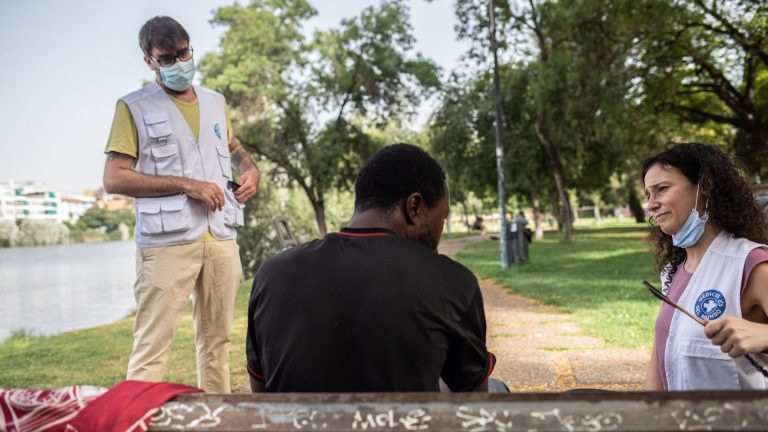 Voluntarios conversan con un hombre en el parque