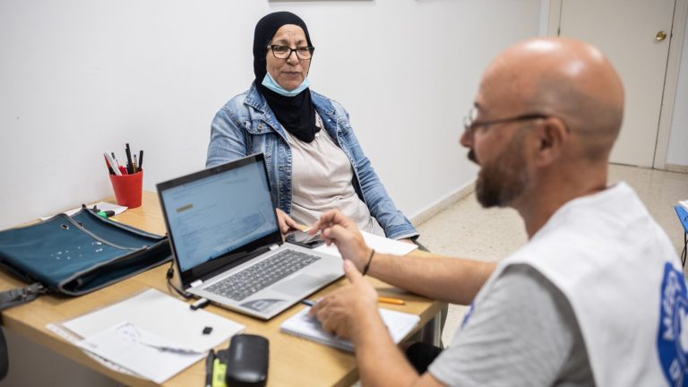 Trabajador de Médicos del mundo atendiendo a una mujer.