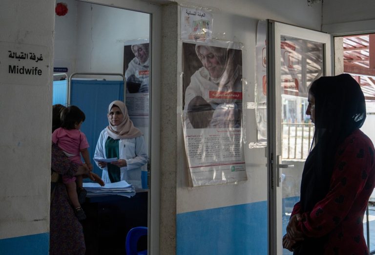 Mujer atendiendo en consulta médica a una madre y su hija.