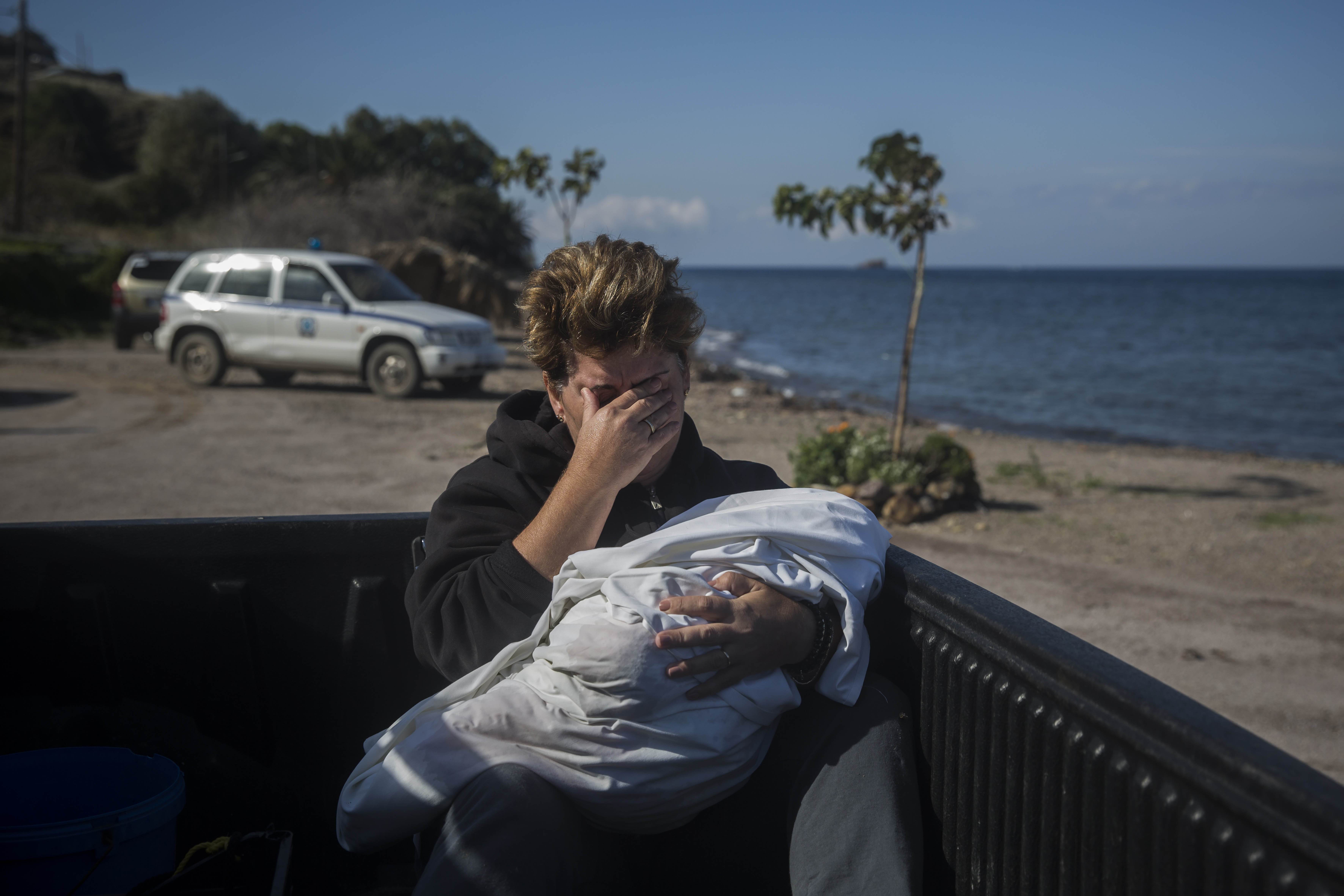 Una vecina del pueblo de Petra llora mientras sujeta el cadáver de un bebé que apareció en las playas cercanas al municipio, en la isla griega de Lesbos. @Santi Palacios