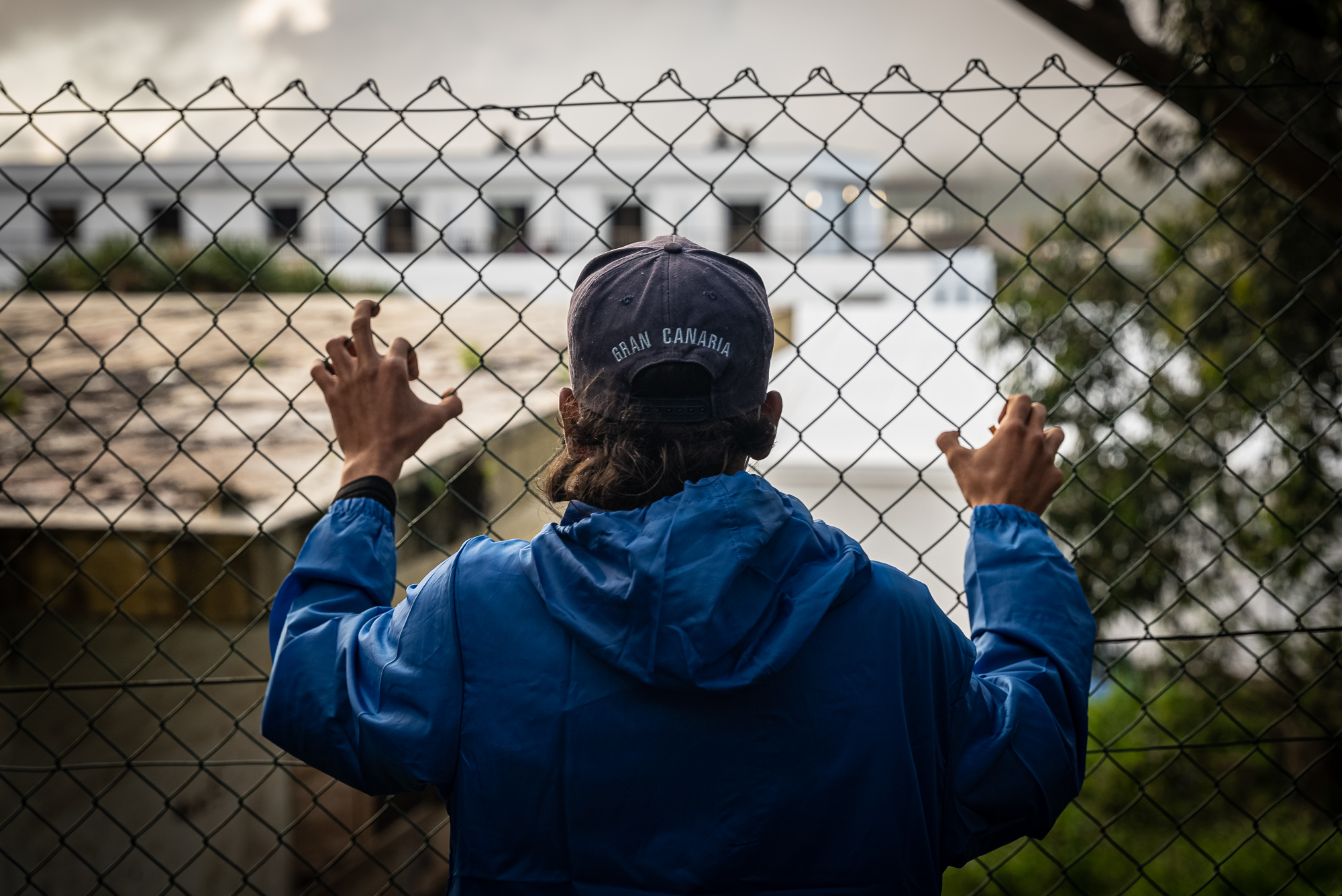 Inmigrante en la verja del campamento "Las Raíces" en Tenerife. Foto: Ignacio Marín.