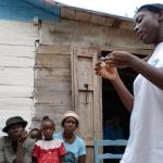 Personal de médicos del mundo explica cómo usar el preservativo bajo la atenta mira de haitianos