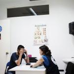 Un inmigrante permanece santado frente a una mediadora en la consulta de Médicos del Mundo Comunidad Valenciana.