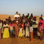 Menores aparecen junto con un formador de Médicos del Mundo en el desierto.