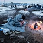 Persona refugiada se protege ante el frio invierno europeo en Serbia